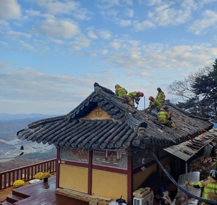 [계룡=뉴시스] 16일 오후 2시56분께 충남 계룡시 엄사면 도곡리 향적산 인근 한 암자에서 불이  나 소방대원들이 지붕에 올라가 진압하고 있다. (사진=계룡소방서 제공) 2024.11.16. photo@newsis.com  *재판매 및 DB 금지