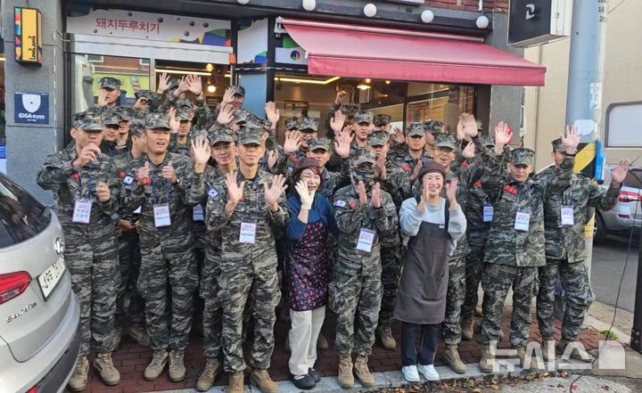 [포항=뉴시스] 송종욱 기자 = 포항시가 지역 먹거리 홍보를 위해 해병대 전역 예정자와 '음식 특화 거리 미식 투어'에 나섰다. 사진은 19일 미식 투어에 나선 해병대 전역 예정자와 식당 관계자가 기념 촬영하는 모습. (사진=포항시 제공) 2024.11.19. photo@newsis.com