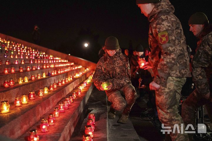 [키이우=AP/뉴시스] 11월 19일 우크라이나 키이우에서 러시아의 우크라이나 침공 1000일을 맞아 전몰자 추모식이 열려 우크라이나 군인들이 촛불을 밝히고 있다. 2024.11.21.