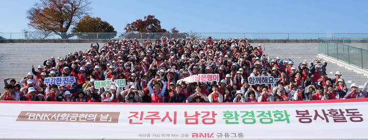 [창원=뉴시스] BNK경남은행 임직원과 가족들이 지난 16일 진주 남강 환경정화 봉사 활동 후 기념촬영을 하고 있다. (사진=BNK경남은행 제공) 2024.11.20. photo@newsis.com  *재판매 및 DB 금지