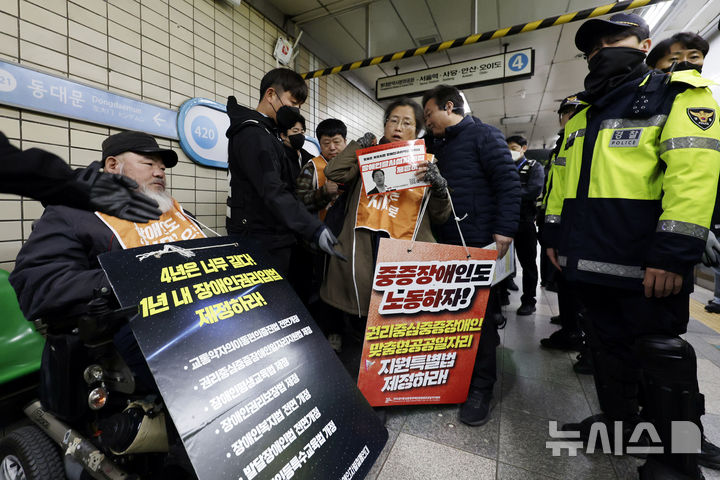 [서울=뉴시스] 최동준 기자 = 전국장애인차별철폐연대가 20일 서울 혜화역에서 장애인 예산 증액 요구 침묵시위를 벌인 뒤 경찰과 서울교통공사의 퇴거 요청에 이동하고 있다. 2024.11.20. photocdj@newsis.com