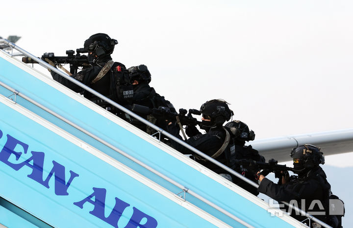 [부산=뉴시스] 하경민 기자 = '2024년도 김해국제공항 대테러 종합훈련'이 열린 20일 부산 강서구 김해국제공항에서 경찰특공대가 인질 테러범을 제압하기 위해 피랍 항공기에 진입하고 있다.      이날 훈련에는 한국공항공사 부산본부, 국가정보원, 부산지방항공청, 국군방첩사령부, 부산경찰청, 공군 제5공중기동비행단, 대한항공 등 12개 기관 120여 명이 참여했으며, 대한항공 A321 여객기를 비롯해 폭발물처리차량, 군 장갑차 등 25종 29대 장비가 동원됐다. 2024.11.20. yulnetphoto@newsis.com