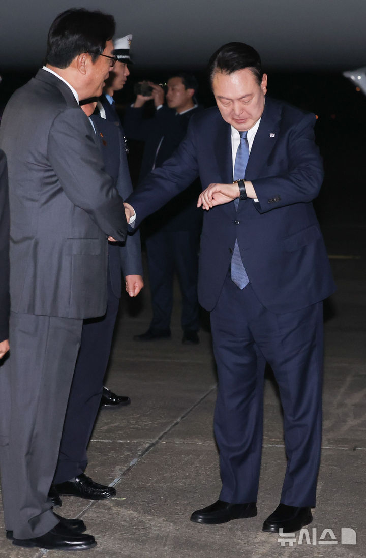 [성남=뉴시스] 조수정 기자 = APEC 정상회의와 G20 정상회의 일정을 마친 윤석열 대통령이 21일 성남 서울공항을 통해 귀국해 공군 1호기에서 내려 환영 나온 정진석 비서실장과 악수하며 시계를 보고 있다. 2024.11.21. chocrystal@newsis.com