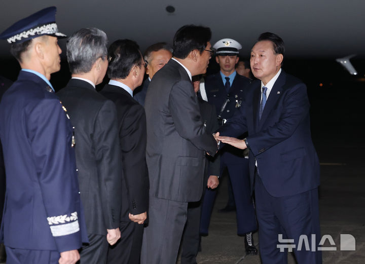 [성남=뉴시스] 조수정 기자 = APEC 정상회의와 G20 정상회의 일정을 마친 윤석열 대통령이 21일 성남 서울공항을 통해 귀국해 공군 1호기에서 내려 환영 나온 정진석 비서실장과 악수하며 손을 두드려주고 있다. 2024.11.21. chocrystal@newsis.com