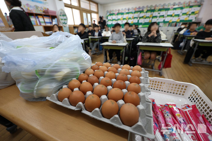 [대구=뉴시스] 이무열 기자 = 학교 급식 조리실무원, 환경미화원, 경비원 등으로 구성된 전국학교비정규직노동조합 대구지부가 파업에 돌입한 21일 대구 한 초등학교 교실에서 초등학생들이 빵, 음료, 계란 등 대체 급식을 받고 있다. 2024.11.21. lmy@newsis.com