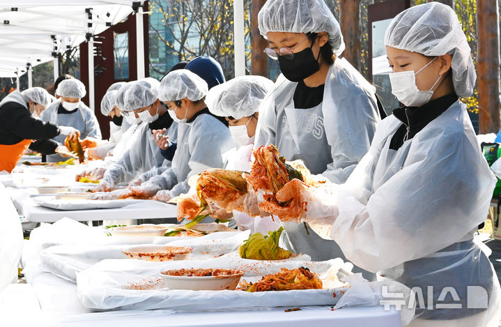 [수원=뉴시스] 김종택기자 = 김치의 날인 22일 경기도 수원시 권선구 국립농업박물관에서 열린 '사랑의 김장 나눔 행사'에서 수원 구운초등학교 학생들이 소외계층에 전달하기 위해 김치를 담그고 있다. 2024.11.22. jtk@newsis.com