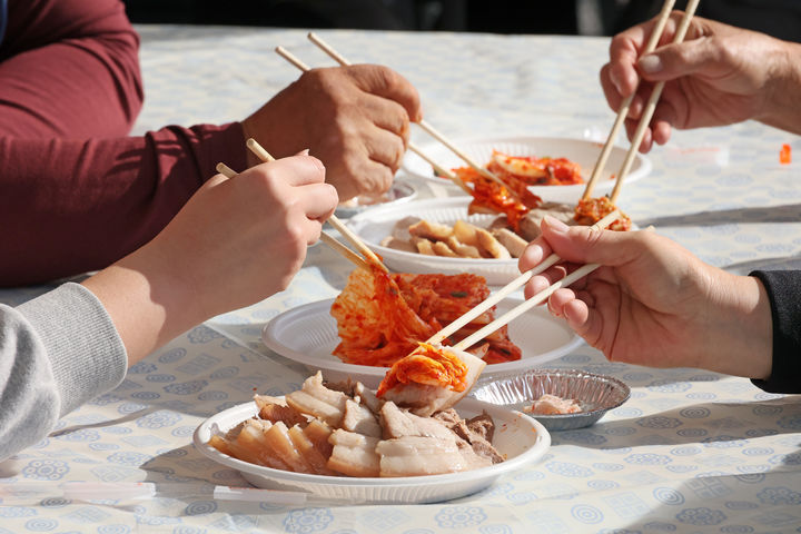 [임실=뉴시스] 김종효 기자 = '제9회 임실 아삭아삭 김장 페스티벌'이 펼쳐지고 있는 지난 23일 임실치즈테마파크, 임실군이 제공한 돼지고기 수육과 자신들이 담근 김장 김치에 참여자 가족들의 젓가락이 모였다. (사진=임실군청 제공) 2024.11.24. photo@newsis.com *재판매 및 DB 금지