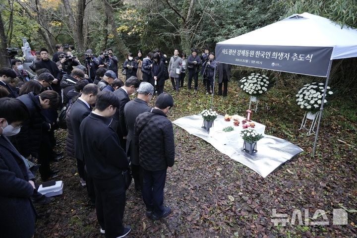 [사도=AP/뉴시스] 25일 일본 니가타현 사도 광산 인근 조선인 기숙사 터에서 일본 정부와 별도로 사도 광산 강제동원 한국인 희생자 추도식이 열려 유족과 한국 정부 관계자들이 묵념하고 있다. 2024.11.25.