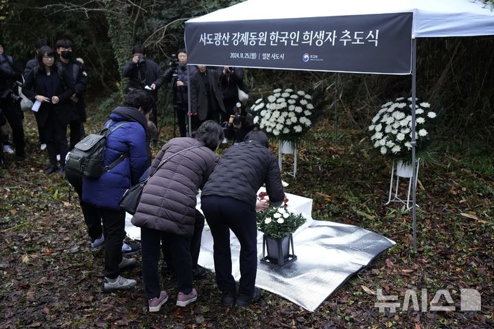 [사도=AP/뉴시스] 25일 일본 니가타현 사도 광산 인근 조선인 기숙사 터에서 일본 정부와 별도로 사도 광산 강제동원 한국인 희생자 추도식이 열려 희생자 유족들이 헌화하고 있다. 2024.11.25.