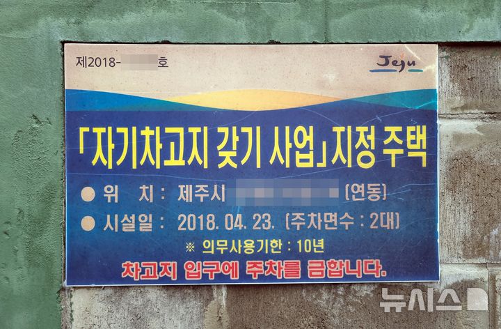 [제주=뉴시스] 우장호 기자 = 차고지 증명제는 자동차를 사거나 명의이전, 주소를 바꿀 때도 반드시 차고지를 확보하도록 한 제도다. 교통난 해소를 위해 2007년 2월 전국에서 유일하게 제주시 동지역 대형 자동차에 한해 시범 도입된 이 제도는 2022년 1월부터 제주 전역 모든 차량을 대상으로 확대됐다. 사진은 제주 시내 골목길 주차 및 차고지증명 안내문 모습. (사진=뉴시스DB) woo1223@newsis.com