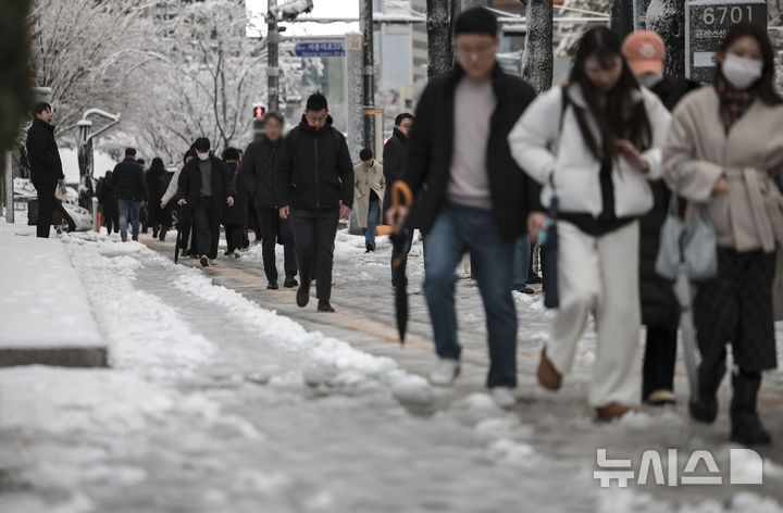 [서울=뉴시스] 정병혁 기자 = 눈이 내린 27일 서울 중구 서울시청 인근에서 시민들이 빙판길을 걷고 있다. 2024.11.27. jhope@newsis.com