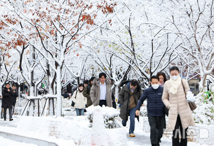 [서울=뉴시스] 황준선 기자 = 다음 주(12월2일~8일)는 전국에 구름이 많이 끼겠고 수도권, 전라권, 제주도 등에 비 소식이 있다. 사진은 서울에 대설특보가 발효된 지난 27일 오전 서울 종로구 세종대로에서 시민들이 발걸음을 옮기고 있는 모습. 2024.11.27. hwang@newsis.com