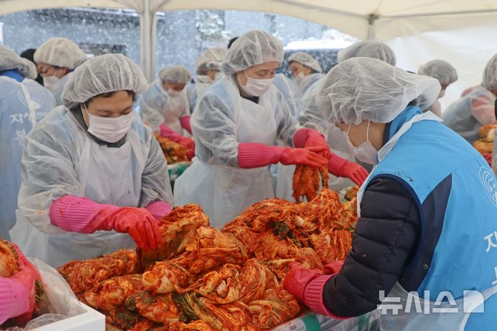 [서울=뉴시스]자생한방병원 임직원들과 자생봉사단원들이 폭설 속에서 김장김치를 담그고 있다. (사진= 자생한방병원 제공) 2024.11.28. photo@newsis.com. 