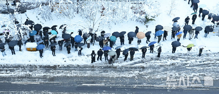 [수원=뉴시스] 김종택 기자 = 수도권 지역에 많은 눈이 내린 28일 경기도 수원시 영통구 망포동 한 버스정류장에서 출근길 시민들이 버스를 기다리고 있다. 2024.11.28. jtk@newsis.com