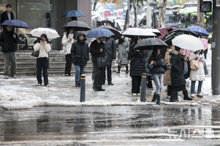 [서울=뉴시스] 정병혁 기자 = 28일 서울 강남구 뱅뱅사거리 인근 배수로가 낙엽과 눈으로 막히면서 물이 고여있는 횡단보도를 시민들이 지나고 있다. 2024.11.28. jhope@newsis.com