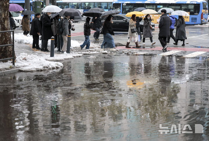 [서울=뉴시스] 정병혁 기자 = 28일 서울 강남구 뱅뱅사거리 인근 배수로가 낙엽과 눈으로 막히면서 물이 고여있는 횡단보도를 시민들이 지나고 있다. 2024.11.28. jhope@newsis.com