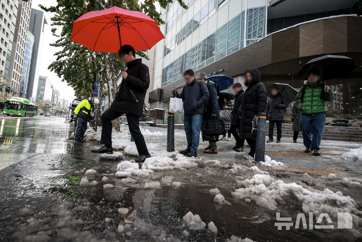 [서울=뉴시스] 정병혁 기자 = 28일 서울 강남구 뱅뱅사거리 인근 배수로가 낙엽과 눈으로 막히면서 물이 고여있는 횡단보도를 시민들이 지나고 있다. 2024.11.28. jhope@newsis.com