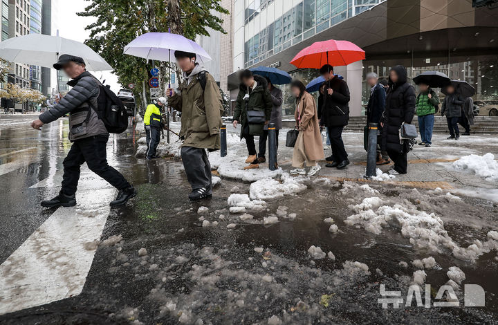 [서울=뉴시스] 정병혁 기자 = 28일 서울 강남구 뱅뱅사거리 인근 배수로가 낙엽과 눈으로 막히면서 물이 고여있는 횡단보도를 시민들이 지나고 있다. 2024.11.28. jhope@newsis.com