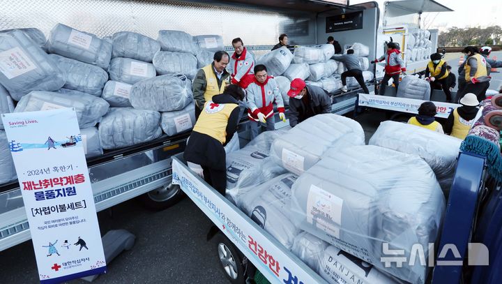 [부산=뉴시스] 대한적십자사 부산지사 임직원과 자원봉사원 등이 28일 오전 부산 부산진구 부산시민공원 야외주차장에서 취약계층에 전달할 차렵이불세트를 화물차에 나눠 싣고 있다. (사진=뉴시스 DB) photo@newsis.com