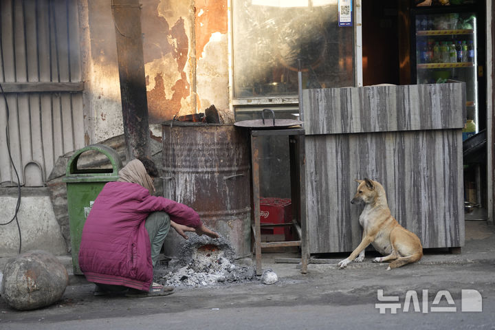 [AP/뉴시스] 29일 인도 북부 카시미르 잠무에서 한 남성이 불을 쬐며 몸을 녹이고 있다 