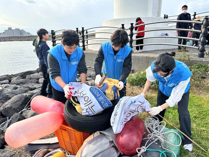 [제주=뉴시스] 제주개발공사 삼다수봉사대는 11월8일 제주항에서 폐현수막으로 만든 마대에 해안쓰레기를 줍는 플로깅 행사를 진행했다. (사진=제주개발공사 제공) 2024.11.29. photo@newsis.com *재판매 및 DB 금지