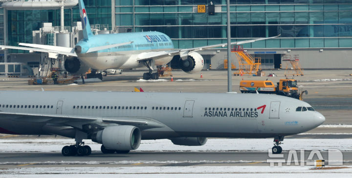 [인천공항=뉴시스] 김선웅 기자 = 대한항공이 아시아나항공과의 기업결합을 위해 유럽연합(EU) 경쟁당국이 제시한 조건부 승인의 선행 조건을 모두 충족하며 28일 사실상 인수 작업 마무리 수순에 들어갔다. 미국 법무부(DOJ)의 심사가 남았지만 양사 합병에 대해 독과점 소송을 제기하지 않는다면 승인으로 간주한다. 대한항공은 미국 DOJ에 EU 경쟁당국의 최종 승인 내용을 보고한 상태다. 지난 2021년 1월 기업결합을 위해 나선 지 약 4년 만이다. 29일 인천국제공항 활주로에서 대한항공·아시아나항공 양사 항공기가 오가고 있다. 2024.11.29. mangusta@newsis.com