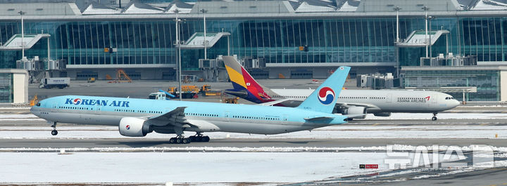 [인천공항=뉴시스] 김선웅 기자 = 대한항공이 아시아나항공과의 기업결합을 위해 유럽연합(EU) 경쟁당국이 제시한 조건부 승인의 선행 조건을 모두 충족하며 28일 사실상 인수 작업 마무리 수순에 들어갔다. 미국 법무부(DOJ)의 심사가 남았지만 양사 합병에 대해 독과점 소송을 제기하지 않는다면 승인으로 간주한다. 대한항공은 미국 DOJ에 EU 경쟁당국의 최종 승인 내용을 보고한 상태다. 지난 2021년 1월 기업결합을 위해 나선 지 약 4년 만이다. 29일 인천국제공항 활주로에서 대한항공·아시아나항공 양사 항공기가 오가고 있다. 2024.11.29. mangusta@newsis.com