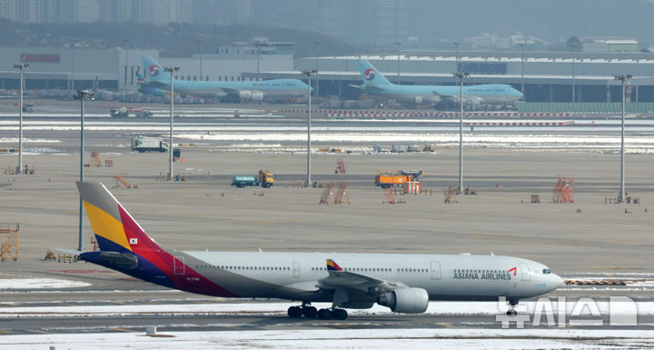 [인천공항=뉴시스] 김선웅 기자 = 대한항공이 아시아나항공과의 기업결합을 위해 유럽연합(EU) 경쟁당국이 제시한 조건부 승인의 선행 조건을 모두 충족하며 28일 사실상 인수 작업 마무리 수순에 들어갔다. 미국 법무부(DOJ)의 심사가 남았지만 양사 합병에 대해 독과점 소송을 제기하지 않는다면 승인으로 간주한다. 대한항공은 미국 DOJ에 EU 경쟁당국의 최종 승인 내용을 보고한 상태다. 지난 2021년 1월 기업결합을 위해 나선 지 약 4년 만이다. 29일 인천국제공항 활주로에서 대한항공·아시아나항공 양사 항공기가 오가고 있다. 2024.11.29. mangusta@newsis.com