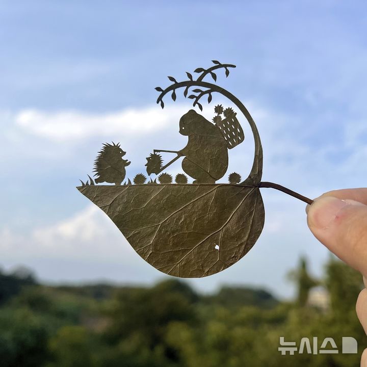 This undated photo provided by Japanese leaf-cutting artist, who goes by the name Lito, shows his work titled: "Wait a second! That's my baby!" (Lito via AP)