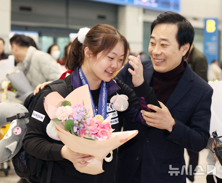 [인천공항=뉴시스] 김진아 기자 = 2024 국제탁구연맹(ITTF) 세계청소년선수권대회 U-19 여자단체전에서 우승을 차지한 유예린이 1일 인천국제공항을 통해 귀국, 아버지 유남규 한국거래소 감독으로부터 축하를 받고 있다. 2024.12.01. bluesoda@newsis.com