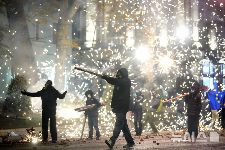 [트빌리시=AP/뉴시스] 4일(현지시각) 조지아 트빌리시에서 정부의 유럽연합(EU) 가입 협상 중단 결정을 규탄하는 시위대가 폭죽을 터트리고 있다. 조지아 경찰이 4일(현지시각) 유럽연합(EU) 가입 협상을 중단하기로 한 여당 결정에 반대하는 대규모 시위 물결을 진압하기 위해 야당 사무실을 급습, 지도자를 체포했다. 2024.12.05.
