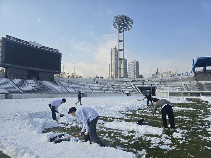 [서울=뉴시스] 그라운드에 쌓인 눈을 직접 제설하고 있는 프로축구 K리그2 서울이랜드 프런트 및 사업소 관계자. (사진=서울이랜드 제공) *재판매 및 DB 금지