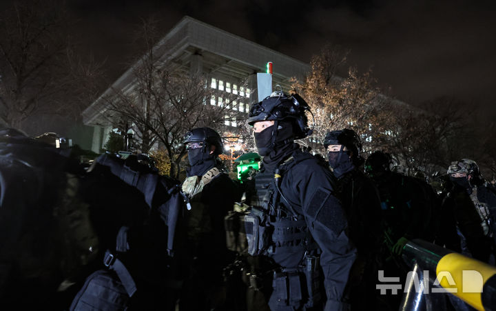 [서울=뉴시스] 고승민 기자 = 국회 본회의에서 비상계엄 해제를 의결한 4일 새벽 계엄군 병력이 국회 후문에서 철수하고 있다. 2024.12.04. kkssmm99@newsis.com