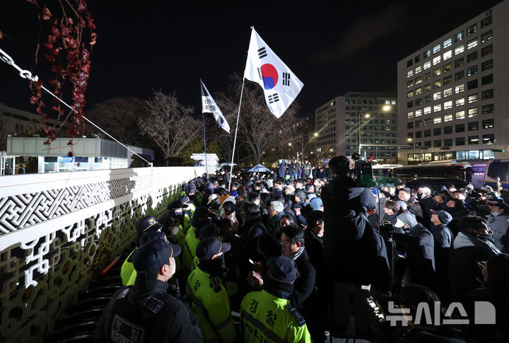 [서울=뉴시스] 김진아 기자 = 윤석열 대통령의 비상계엄 해제 요구 결의안이 국회 본회의에서 통과된 4일 새벽 서울 영등포구 국회 정문 앞에서 시민들이 윤석열 대통령 퇴진 촉구 구호를 외치고 있다. 2024.12.04. bluesoda@newsis.com