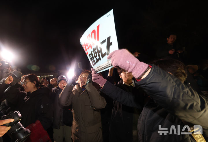 [서울=뉴시스] 김명년 기자 = 윤석열 대통령이 국회 계엄해제령 관련해 담화문을 발표한 가운데 4일 새벽 서울 여의도 국회 인근에서 시민들이 기뻐하고 있다. 2024.12.04. kmn@newsis.com