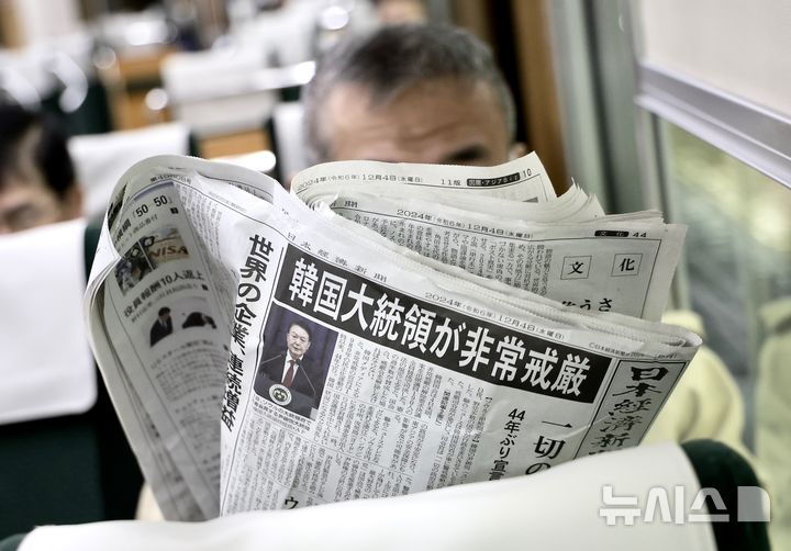 [오사카=뉴시스] 정병혁 기자 = 윤석열 대통령의 비상계엄 관련 소식이 4일 일본 니혼게이자이신문 조간 1면에 보도되어 일본 오사카우메다역에서 한 시민이 신문을 읽고 있다. 2024.12.04. jhope@naver.com