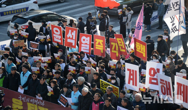 [전주=뉴시스] 김얼 기자 = 윤석열퇴진전북행동본부 관계자들이 4일 전북 전주시 관통로사거리에서 '비상계엄 선포 결의대회'를 열고 구호를 외치고 있다. 2024.12.04. pmkeul@newsis.com