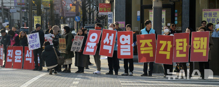 [전주=뉴시스] 김얼 기자 = 윤석열퇴진전북행동본부 관계자들이 4일 전북 전주시 관통로사거리에서 '비상계엄 선포 결의대회'를 열고 손피켓 홍보전을 하고 있다. 2024.12.04. pmkeul@newsis.com