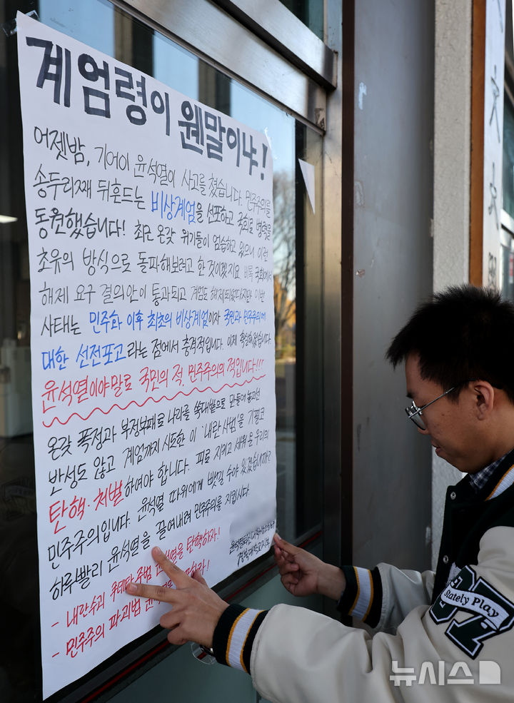 [대구=뉴시스] 이무열 기자 = 4일 대구 북구 경북대학교 인문대학 입구에서 윤석열 퇴진 대학운동본부 경북대학교지부가 윤 대통령 탄핵을 촉구하는 대자보를 붙이고 있다. 2024.12.04. lmy@newsis.com