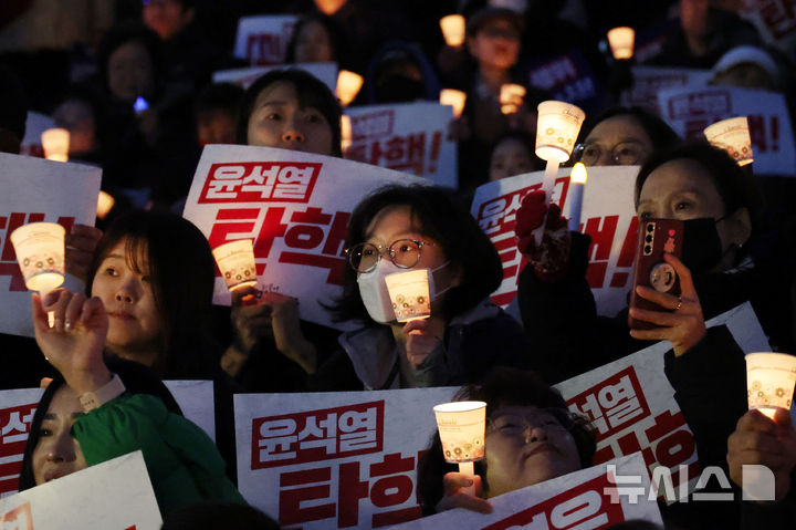 [서울=뉴시스] 조성우 기자 = 지난 4일 오후 서울 여의도 국회에서 열린 윤석열 대통령 사퇴 촉구·탄핵 추진 범국민 촛불문화제 참가자들이 촛불을 들고 구호를 외치고 있다. 2024.12.04. xconfind@newsis.com