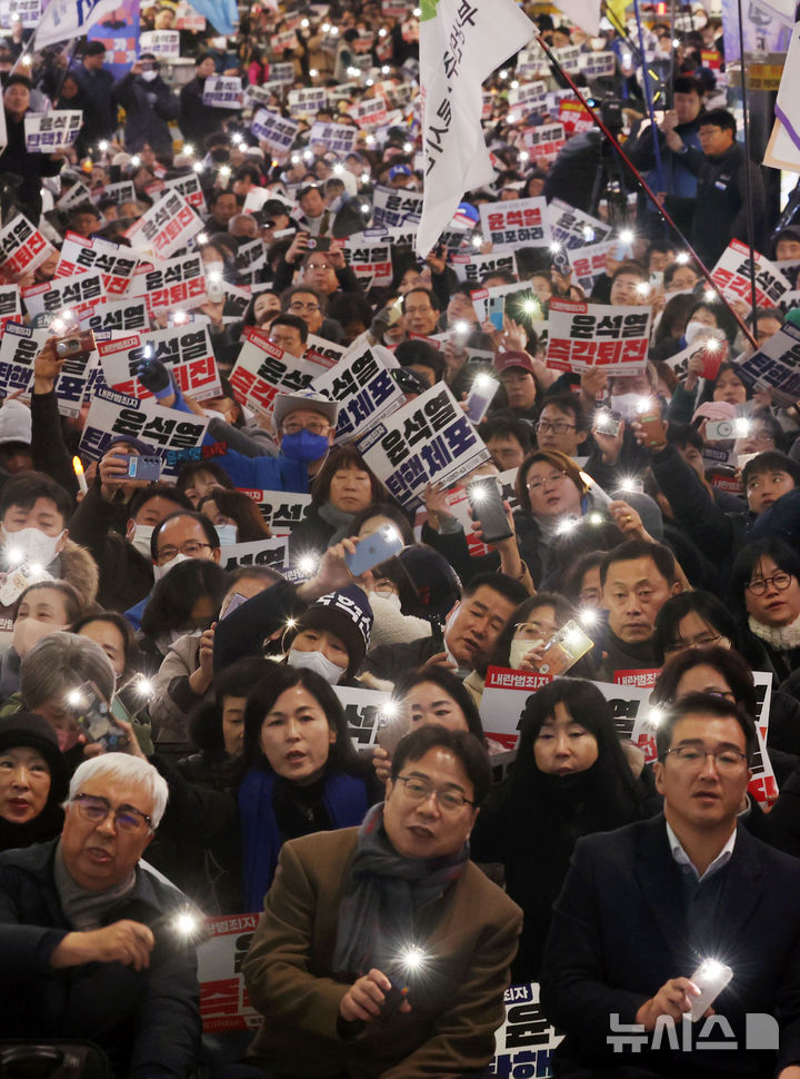 [부산=뉴시스] 하경민 기자 = 부산지역 시민사회단체와 시민 등 2000여명(주최측 추산)이 4일 오후 부산 부산진구 서면에서 비상계엄 선언 사태를 빚은 윤석열 정권의 퇴진을 촉구하는 대규모 집회를 열고 휴대전화 불빛을 비추며 구호를 외치고 있다. 2024.12.04. yulnetphoto@newsis.com