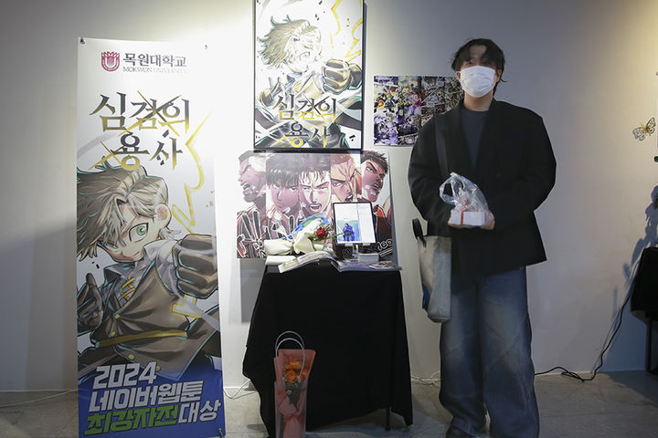 [대전=뉴시스] 대전 목원대미술관에서 열린 웹툰학과 졸업작품전시회에서 문도현씨가 자신의 작품 앞에서 기념촬영을 하고 있다. (사진=목원대 제공) 2024.12.05. photo.newsis.com&nbsp;&nbsp;&nbsp; *재판매 및 DB 금지