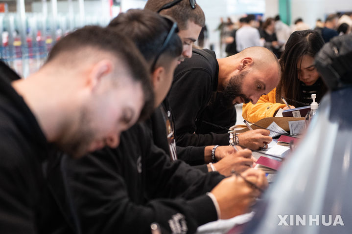 [베이징=신화/뉴시스] 지난해 12월 4일 중국 베이징의 서우두국제공항에서 외국인 방문객들이 입국신고서를 작성하고 있다. 2025.08.14