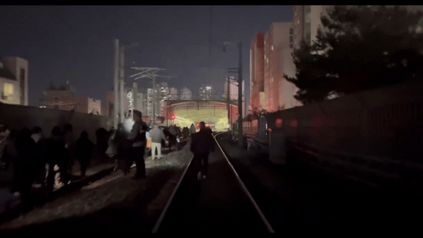 [서울=뉴시스] 퇴근길 회기역에서 중랑역으로 향하던 경의중앙선 열차가 정전된 채로 멈춰 서 있자 승객들이 열차에서 내려 선로를 걸어 중랑역으로 향하는 모습.(사진=엑스 옛 트위터 '임상민' 갈무리) *재판매 및 DB 금지