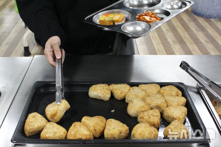 [제주=뉴시스] 양영전 기자 = 학교에서 급식과 돌봄 업무를 맡는 비정규직 노동자들이 총파업에 나선 6일 오후 제주제일중학교에서 학생들이 주먹밥과 떡, 음료 등으로 구성된 대체식을 배식하고 있다. 2024.12.06. 0jeoni@newsis.com