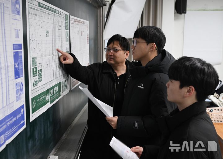 [서울=뉴시스] 사진공동취재단 = 2025학년도 대학수학능력시험(수능) 성적표가 배부된 6일 서울 종로구 동성고등학교에서 고3 담임 선생님이 수험생들과 대학 배치도를 살펴보고 있다. 2024.12.06. photo@newsis.com
