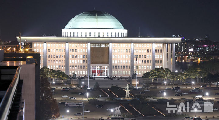 [서울=뉴시스] 김선웅 기자 = 6일 서울 여의도 국회의사당이 환하게 불을 밝히는 앞으로 잔디광장에 헬기 착륙을 방지하기 위한 차량들이 주차돼있다. 2024.12.06. mangusta@newsis.com