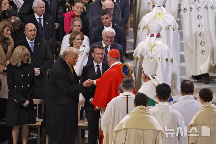 [파리=AP/뉴시스] 에마뉘엘 마크롱프랑스대통령과 도널드 트럼프 미대통령당선인이 12월 7일 노트르담 사원의 재개관식에 참석해서 사원의 추기경을 비롯한 성직자들과 인사하고 있다. 이 성당은 2019년 861년의 역사중 처음으로 대부분이 화재로 소실되었고 5년 동안의 집중 투자와 수많은 노력으로 이 날 공식 재개관식을 가졌다. 2024. 12. 08.&nbsp; 