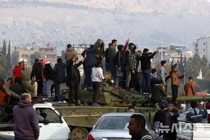 [AP/뉴시스] 8일 다마스쿠스  시민들이 반정부군의 입성을 축하하며 승리 사인을 하고 있다