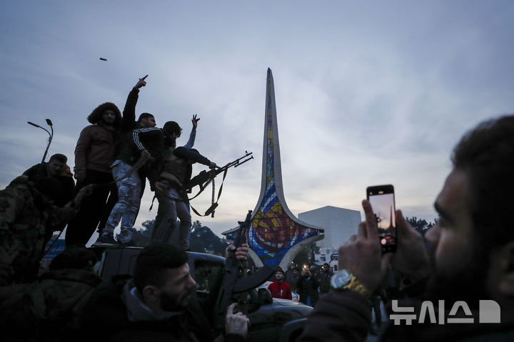 [AP/뉴시스] 8일 다마스쿠스 시민들이 정부군이 버리고 간 무기를 들고 반군 입성 축하해 종중에 총를 쏘고 있다 